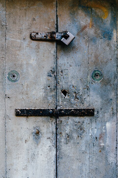 Grey Painted Wooden Door Surface Secured with Iron Latch, Old Padlock, Rusty Hinges and Keyholes