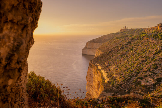 Sunset over Dingli Cliffs Coastline and Ocean Framed by Warm Sunlit Rock Texture, Southwest Malta