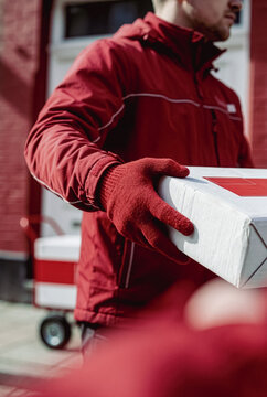 Delivery driver in red uniform holding a package