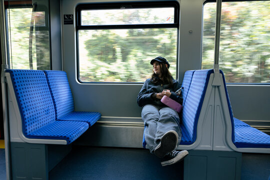 Pensive young woman stretches out on an empty train