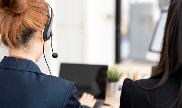 Back View Close Up of Call Center Agents Wearing Headset Working at Office Desk