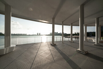 Obraz premium seaside colonnade building with white pillars and sunlight shadows