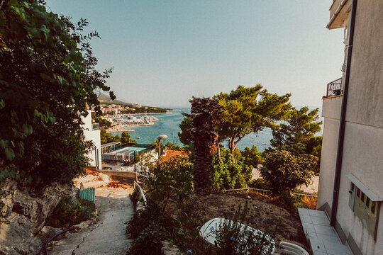Scenic view of coastal town and blue sea bay through narrow village street   