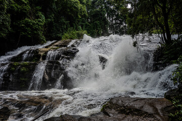 Waterfall cascading over dark rocks in Thailand © Emad Aljumah