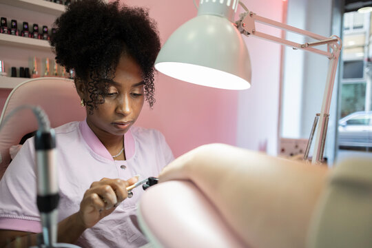 Nail technician providing manicure care in a beauty salon