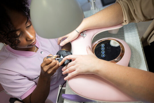 Manicurist tending to a client's nails during a salon manicure