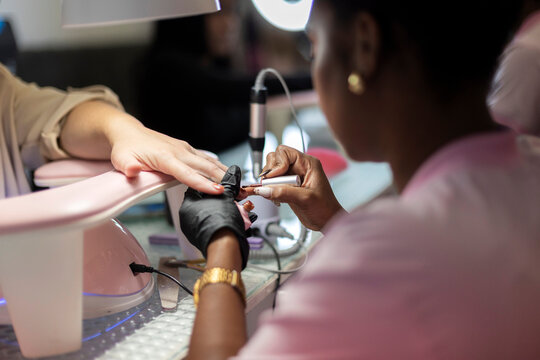 Nail technician applying polish during a salon manicure