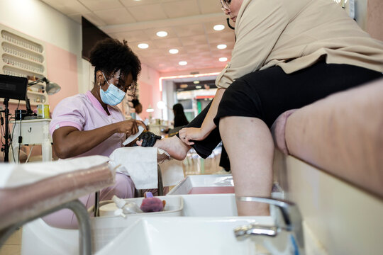 Nail technician providing a pedicure in a beauty salon
