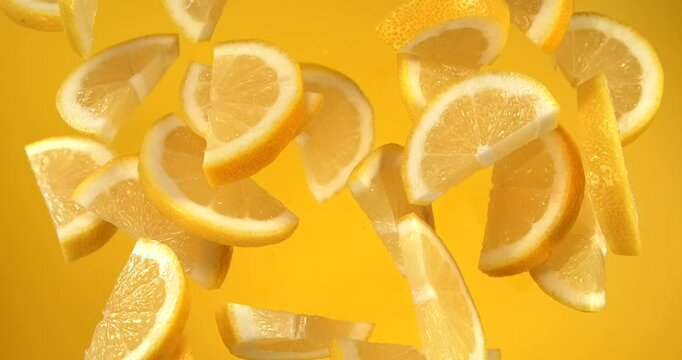 Lemon slices falling in slow motion 1000 fps on yellow background
