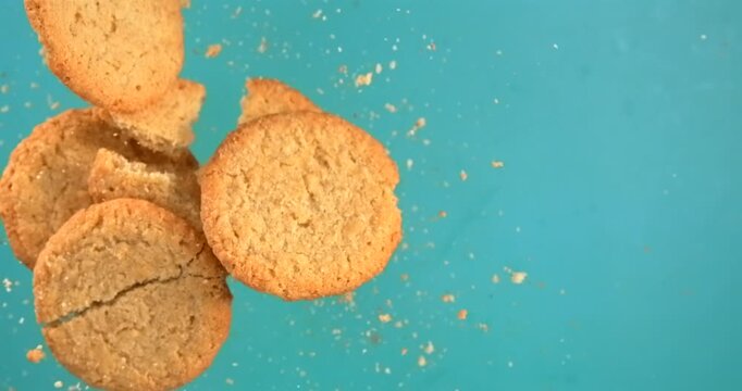 Butter cookies breaking and falling in slow motion 1000 fps on blue background