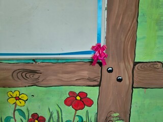 Hand painted wall mural with wooden frame pattern and blooming flowers around school whiteboard corner © Hendra Susanto0311