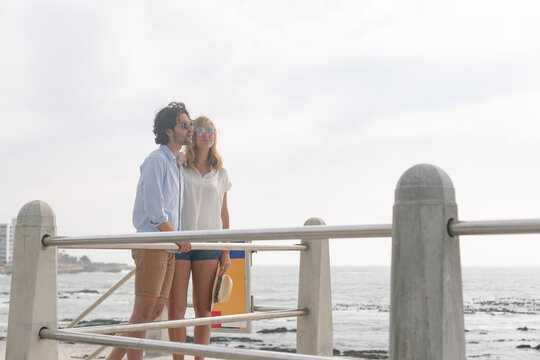 Caucasian couple interacting with each other on the promenade at the seaside
