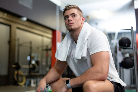 Male athletic relaxing in fitness center