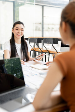 Vertical View of Asian Businesswoman Smiling and Listening in Office Meeting