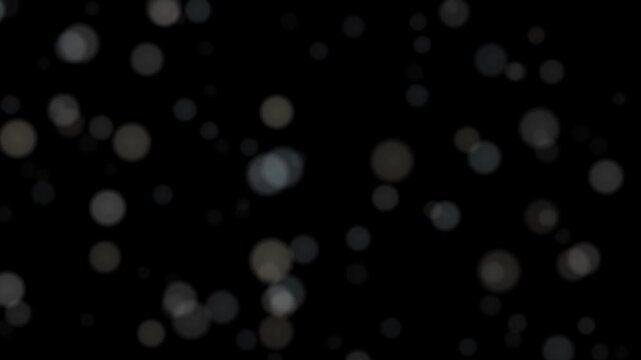 Subtle blurred light orbs drift gently against a deep black background, creating a dreamy atmospheric texture with soft glowing illumination and delicate particle effects.