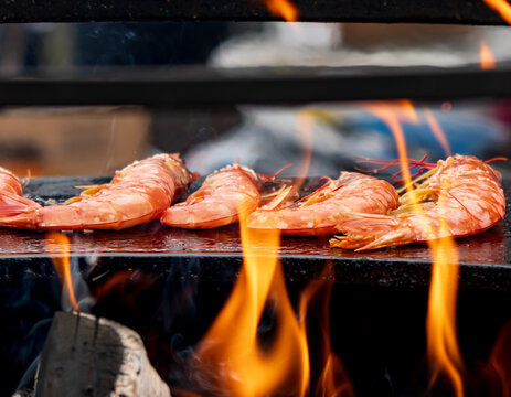 Fresh shrimp sizzle over vibrant, dancing flames
