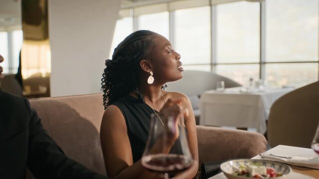 Young African American woman calling Caucasian waiter during luxury restaurant dinner. Footage suitable for hospitality commercials and gastronomy advertising