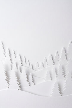 Papierschnitt Winterwald mit Tannen in Wei&szlig;