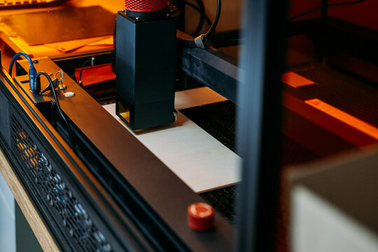 Laser engraver in enclosure with red emergency stop button. Emergency stop button, machine safety, operator protection, safety interlock