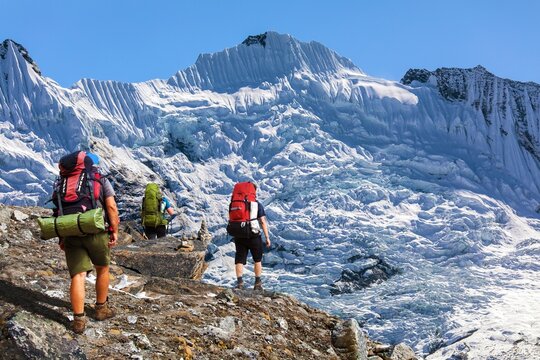 three tourists hikers on moraine Nepal Himalaya mountain
