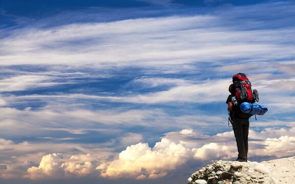 climber or hiker or tourist on sunset sky background
