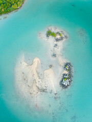 Wide aerial panorama of a secluded tropical paradise island with turquoise lagoon and coral reefs © Anthony Lewis