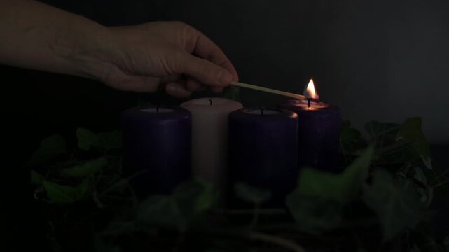 Lighting candles on an Advent wreath for Christmas preparation video.