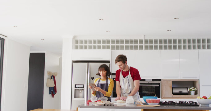 Image of happy diverse couple baking together in kitchen