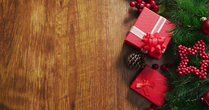 Image of christmas decorations with presents and copy space on wooden background