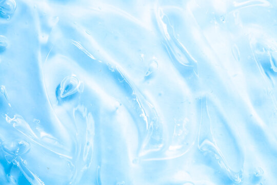 Cosmetic gel, serum, clear sample with a blue tint, close-up. Liquid cream with a foaming texture. Gel texture of a cosmetic product. Liquid cosmetic lotion for skin care.