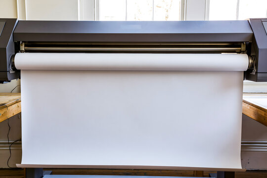 Large Format Printer Feeding Blank White Paper Roll in Professional Print Workshop