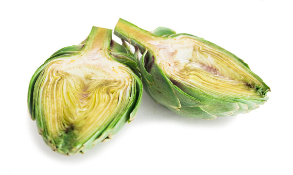 two delicious halves of ripe green artichokes on a white background