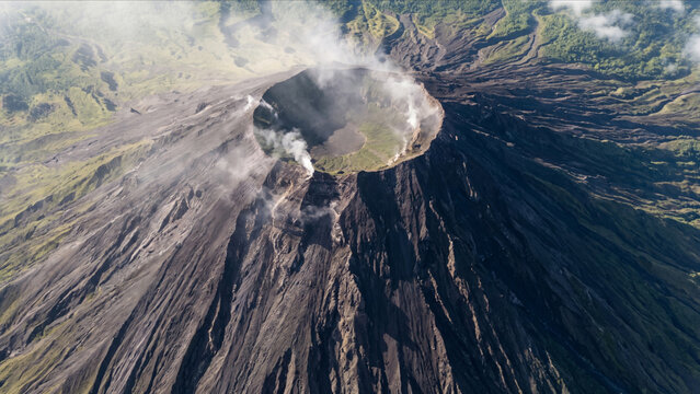 マヨン火山火口縁の玄武岩岩壁と噴き出す火山性噴煙の様子