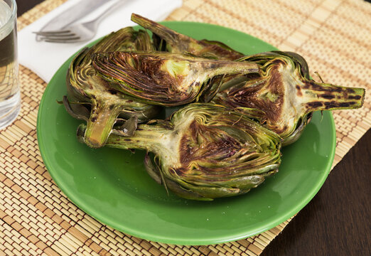 cooked fried halves artichokes on green plate