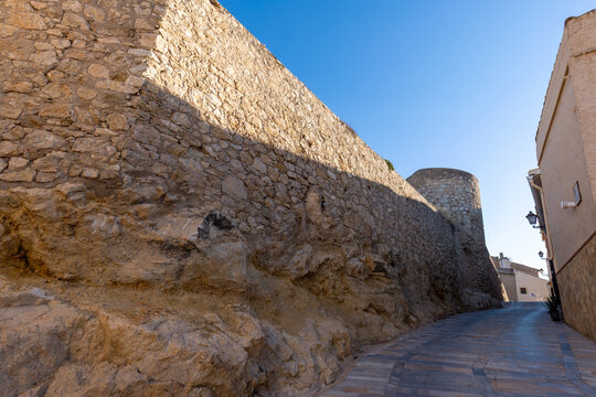 City walls at the foot of Biar Castle, Alicante (Spain), bathed in morning light