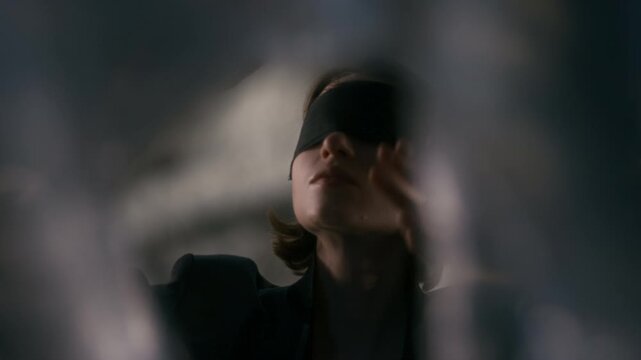 Blindfolded Caucasian young adult woman reaching out hands and touching glass surface. Footage suitable for mental health awareness, psychology projects and sensory perception marketing