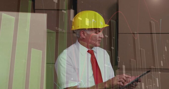 Reviewing supervisor in yellow hard hat and red tie using tablet at site office, with charts
