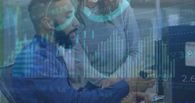 Analyzing bearded man blue shirt checking monitors office, woman grey sweater pointing charts phone