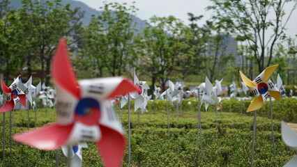 South Korean flag themed pinwheels spinning in a green public park © 정진 조