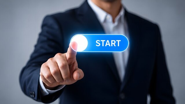 A professional businessman in a suit pressing a glowing virtual start button on a digital interface, representing innovation, technology, and business initiation.