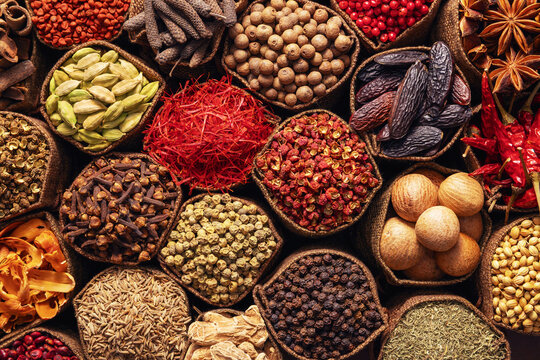 Composition with assortment of spices and herbs in cloth bags, variety of colorful seasonings on the counter