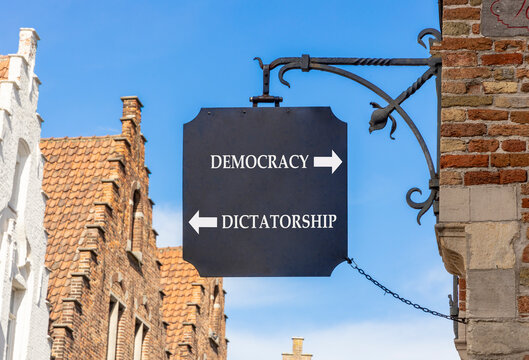 Democracy or dictatorship words symbol. Concept words Democracy Dictatorship on beautiful black road sign. Beautiful blue sky background. Business democracy dictatorship concept. Copy space