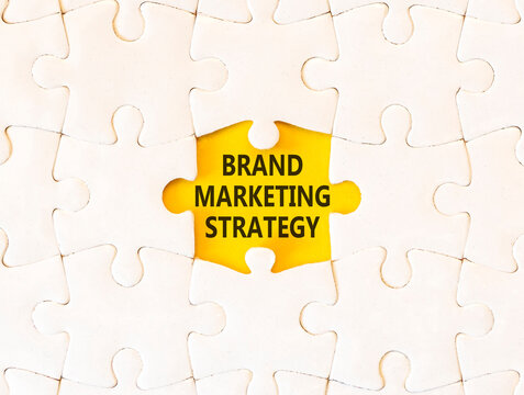 Brand marketing strategy words symbol. Concept words Brand marketing strategy on beautiful white puzzle. Beautiful yellow background. Business and brand marketing strategy concept. Copy space.