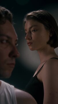Vertical video of young adult Caucasian woman and man standing apart with serious expressions showing relationship conflict. Perfect for counseling ads, mental health campaigns, drama projects