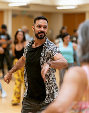 Latin dance instructor leading a class in community center in Community and Social Context