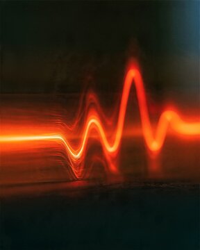 Orange Warning Pulse Waveform on a Dark Surface