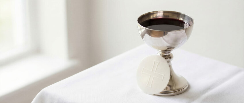 Communion chalice with red wine and communion wafer on white altar cloth. Christian Eucharist and Holy Communion sacrament. Catholic worship and church ritual. Faith, remembrance