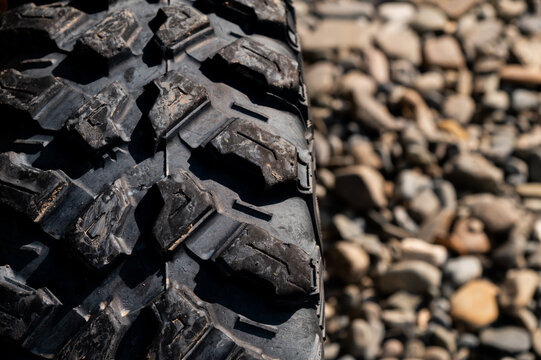Close-up of off-road tire tread on gravel
