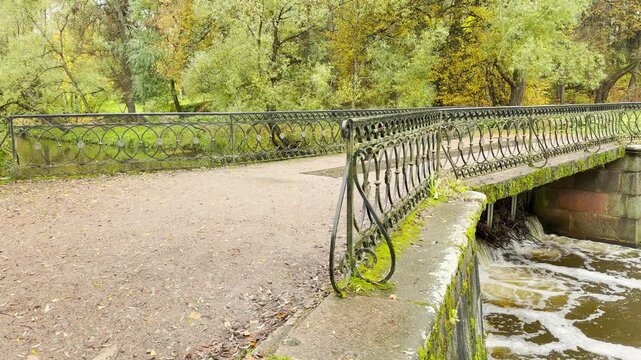 POV walkthrough of an empty Black Bridge-Dam in Pavlovsk Park, shot on stabilizer. Smooth forward camera motion, no people.