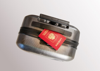 Dark gray plastic suitcase with black handle and zipper on light gray background. Red Russian passport with gold emblem lying on top. Travel, tourism, emigration, escape and forced relocation theme. © Ninaveter